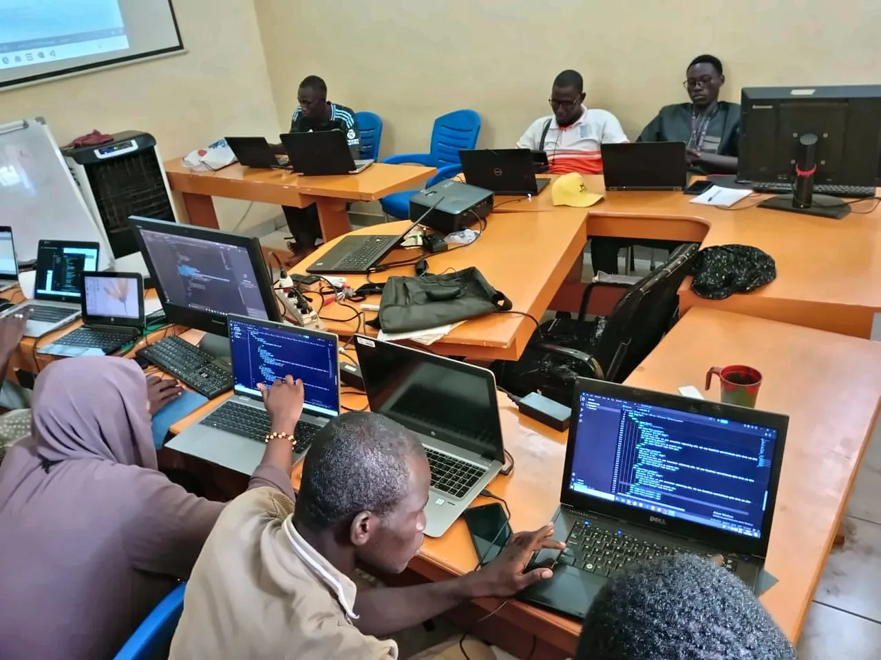 Salle de formation en U, du code à l’écran des ordinateurs